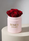 Bordowe wieczne róże w małym pudroworóżowym flower boxie – elegancki prezent