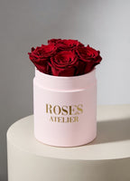 Bordowe wieczne róże w małym pudroworóżowym flower boxie – elegancki prezent