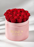 Czerwone wieczne róże w dużym różowym flower boxie