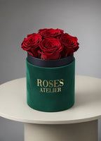 Zielony flower box z ciemnoczerwonymi wiecznymi różami